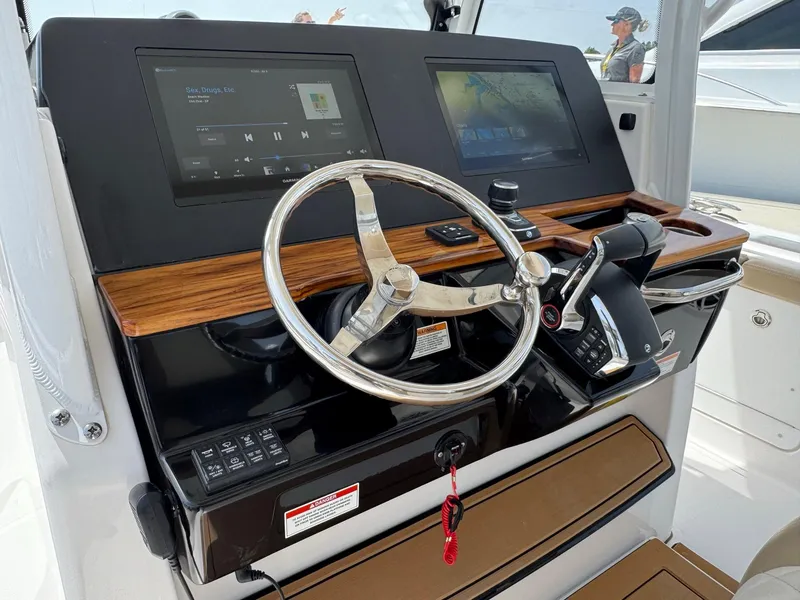 Slide: The Image of 2024 Everglades 315CC boat dashboard with dual screens and steering wheel. - 29