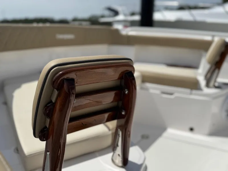 Slide: The Image of 2024 Everglades 315CC boat interior with cushioned seating and wooden accents. - 37