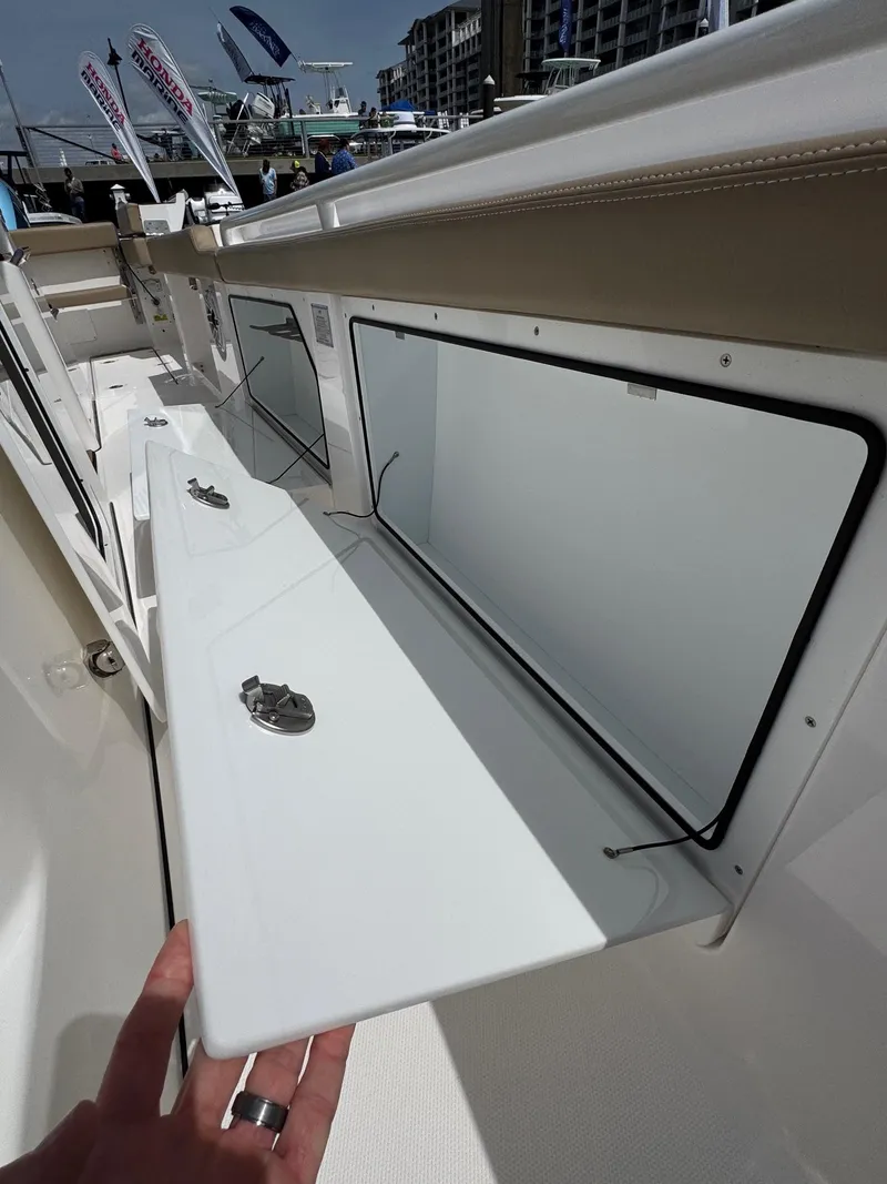 Slide: The Image of 2024 Everglades 315CC boat storage compartment with open hatch, showcasing sleek design and functionality. - 45