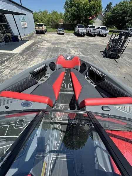 Slide: The Image of 2024 Tigé Z5 boat with red and gray interior, parked outdoors. - 4