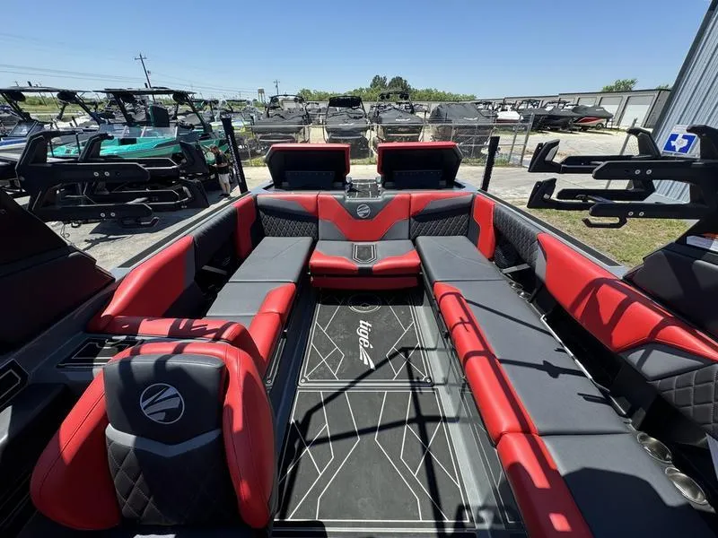 Slide: The Image of 2024 Tigé Z5 boat interior with red and black seating, docked outdoors. - 5
