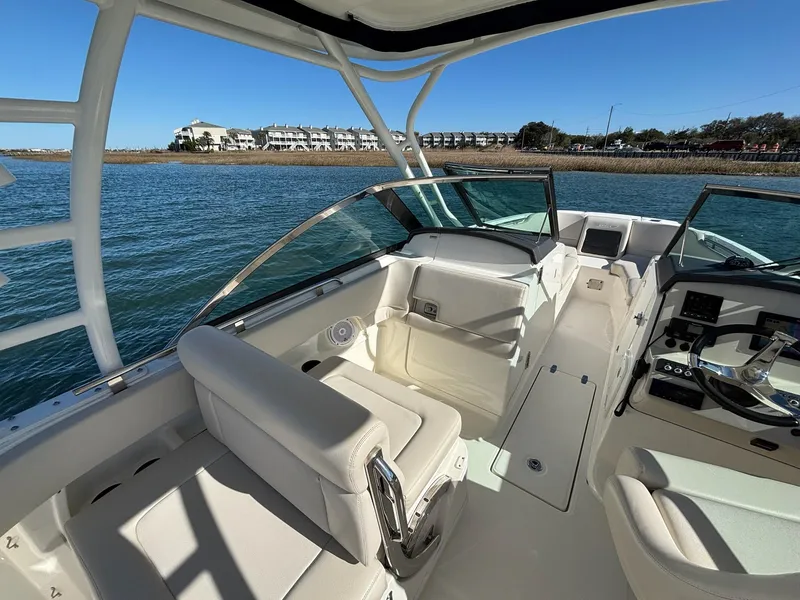 Slide: The Image of 2018 Boston Whaler 230 Vantage boat cruising on a calm lake near a residential area. - 10