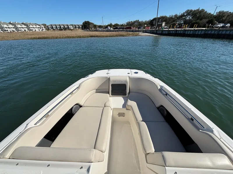 Slide: The Image of 2018 Boston Whaler 230 Vantage boat on calm water, featuring spacious seating area. - 13