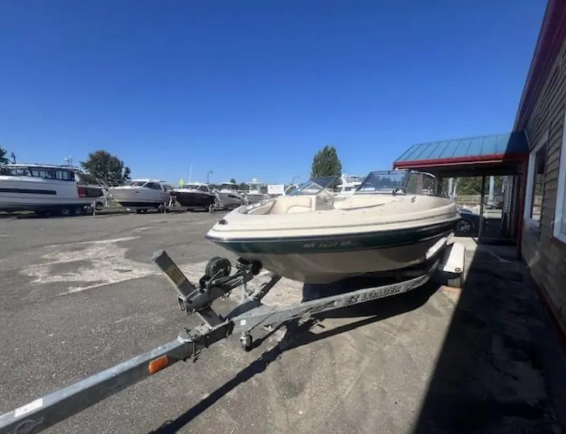 Slide: The Image of 2003 Glastron GX 185 boat on trailer in outdoor lot under clear blue sky. - 3
