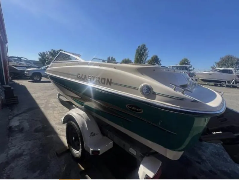 Slide: The Image of 2003 Glastron GX 185 boat on trailer, parked outdoors under clear blue sky. - 4