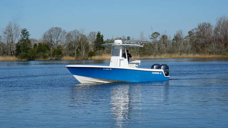 Slide: The Image of 2015 Contender 25 Tournament boat on calm water, surrounded by trees. - 24