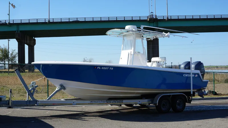 Slide: The Image of 2015 Contender 25 Tournament boat on trailer, parked near a bridge. - 27