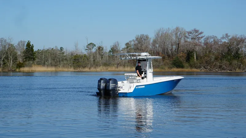 Slide: The Image of 2015 Contender 25 Tournament boat on calm water, surrounded by trees. - 30