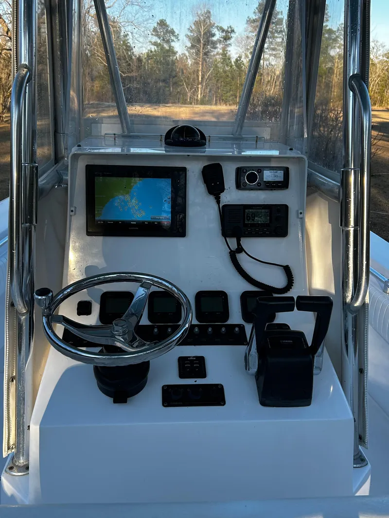 Slide: The Image of 2015 Contender 25 Tournament boat console with steering wheel, navigation screen, and controls. - 32