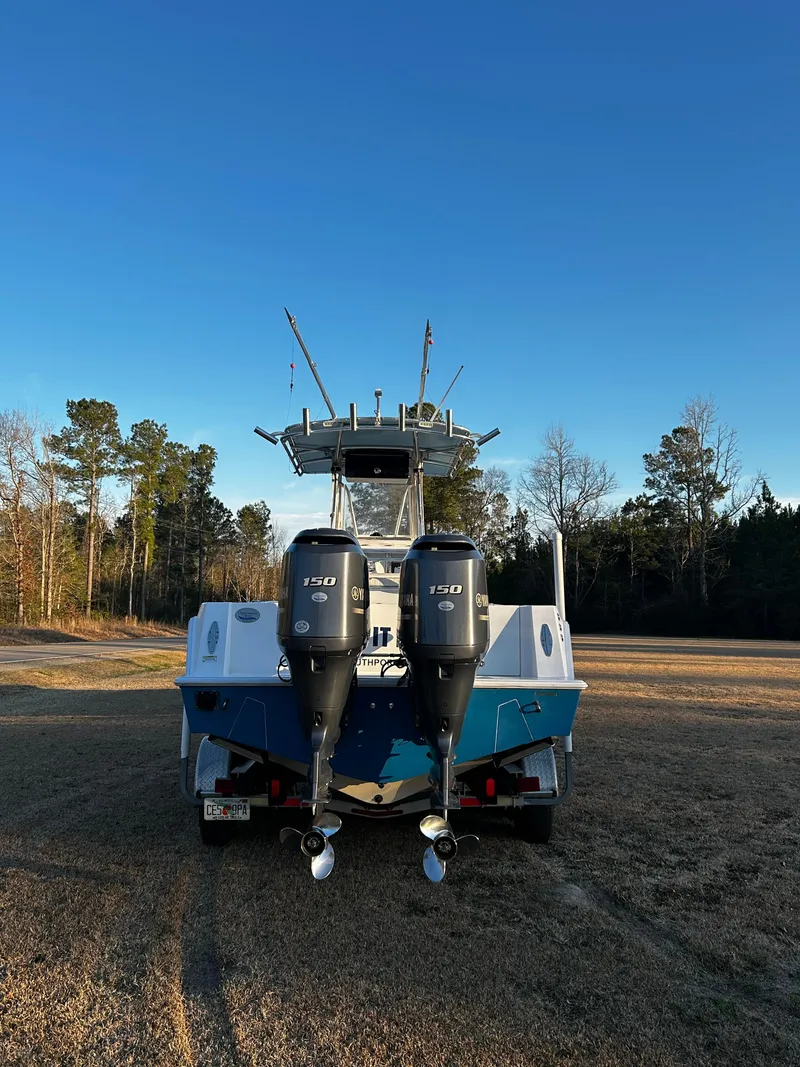 Slide: The Image of 2015 Contender 25 Tournament boat with dual engines, parked on grass under clear blue sky. - 34