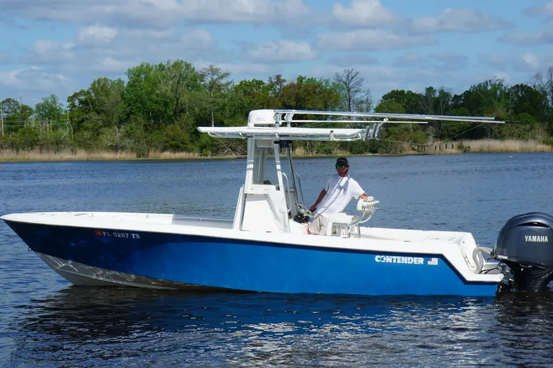 Slide: The Image of 2015 Contender 25 Tournament boat on water with Yamaha engine, clear sky, and trees in background. - 42