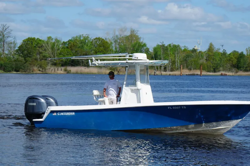 Slide: The Image of 2015 Contender 25 Tournament boat on water with Yamaha engines, surrounded by trees. - 43