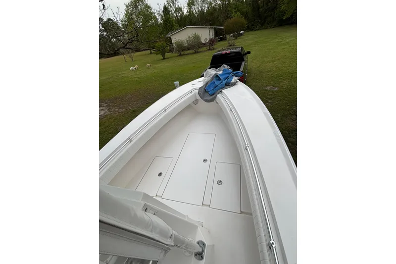 Slide: The Image of 2015 Contender 25 Tournament boat on grassy yard near a house and truck. - 46
