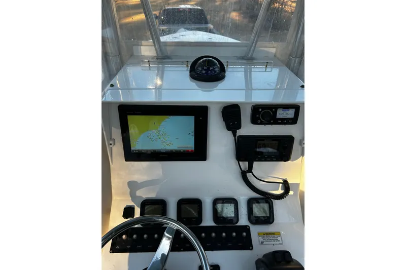 Slide: The Image of Center console of a 2015 Contender 25 Tournament boat with navigation and communication equipment. - 49