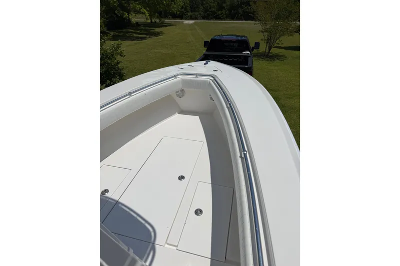 Slide: The Image of 2015 Contender 25 Tournament boat on trailer, parked on grassy area. - 51