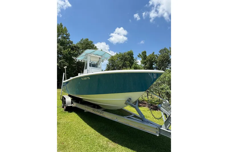Slide: The Image of 2015 Contender 25 Tournament boat on trailer, parked on grass under blue sky. - 59