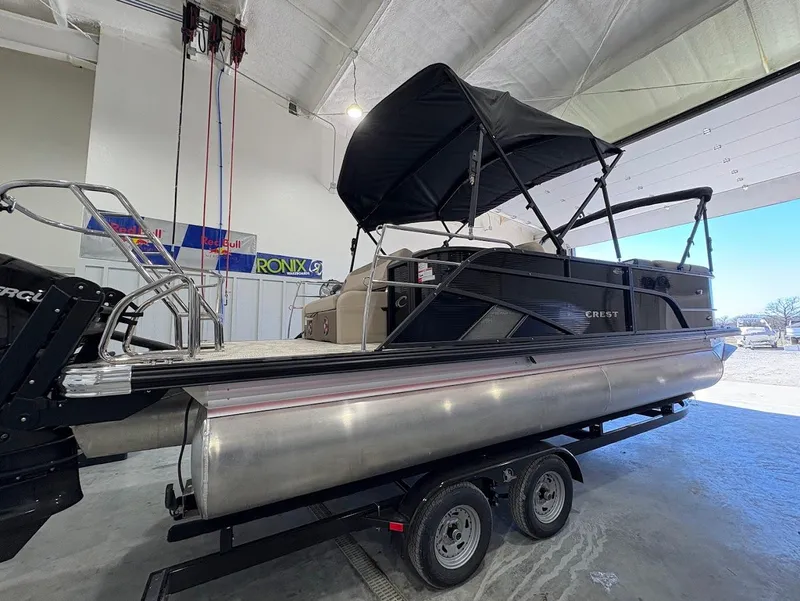 Slide: The Image of 2025 Crest Classic 220 pontoon boat on trailer in indoor showroom. - 4
