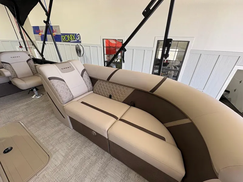 Slide: The Image of 2025 Crest Classic 220 pontoon boat with Mercury engine on trailer in showroom. - 6