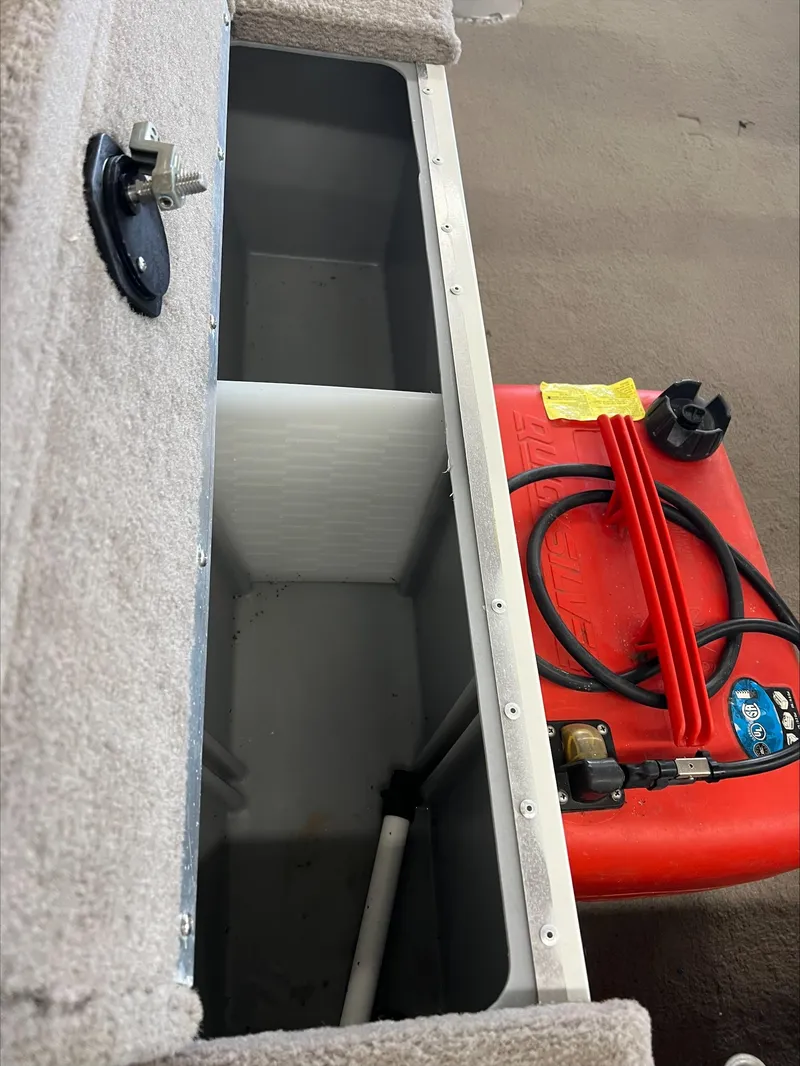 Slide: The Image of 2005 Starcraft Wb 16 D-Star boat storage compartment with red fuel tank and hoses. - 7