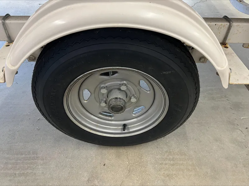 Slide: The Image of Trailer wheel of a 2005 Starcraft Wb 16 D-Star, featuring a metal rim and black tire. - 8