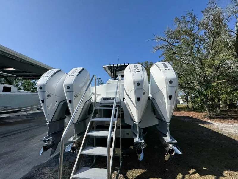 Slide: The Image of 2025 Invincible 38 Catamaran with four powerful outboard engines, parked outdoors. - 13