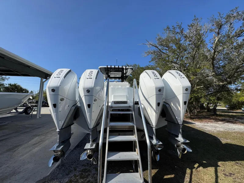 Slide: The Image of 2025 Invincible 38 Catamaran with four powerful outboard engines, parked outdoors. - 14