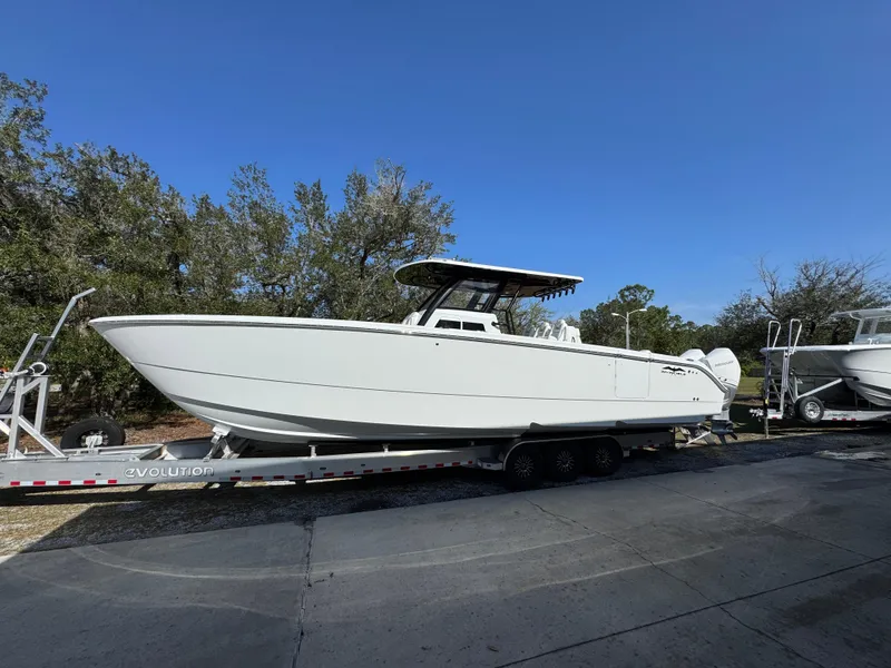 Slide: The Image of 2025 Invincible 38 Catamaran on trailer, sleek design, parked outdoors. - 2