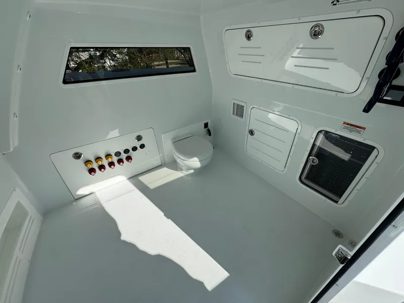 Slide: The Image of 2025 Invincible 38 Catamaran interior with modern controls and compact toilet area. - 20