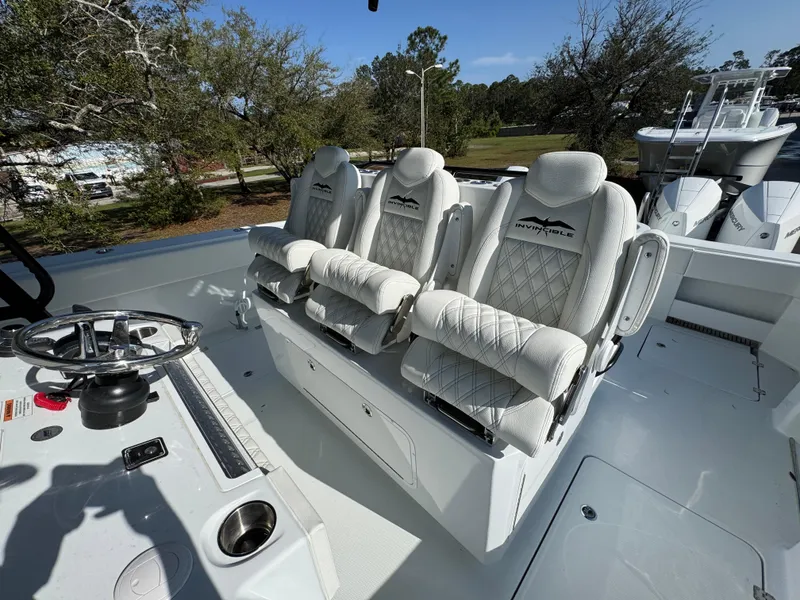 Slide: The Image of 2025 Invincible 38 Catamaran interior with three luxurious white seats and steering wheel. - 23