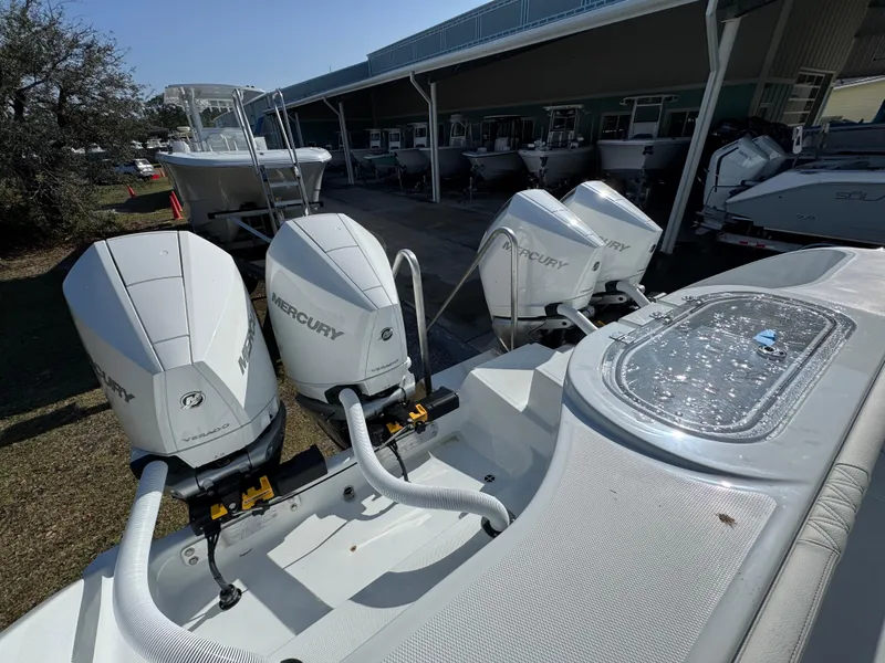 Slide: The Image of 2025 Invincible 38 Catamaran with powerful Mercury outboard engines, docked at a marina. - 33