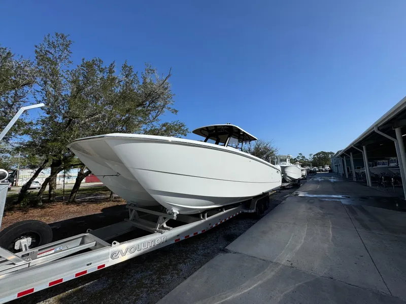 Slide: The Image of 2025 Invincible 38 Catamaran on trailer, parked outdoors under clear blue sky. - 5