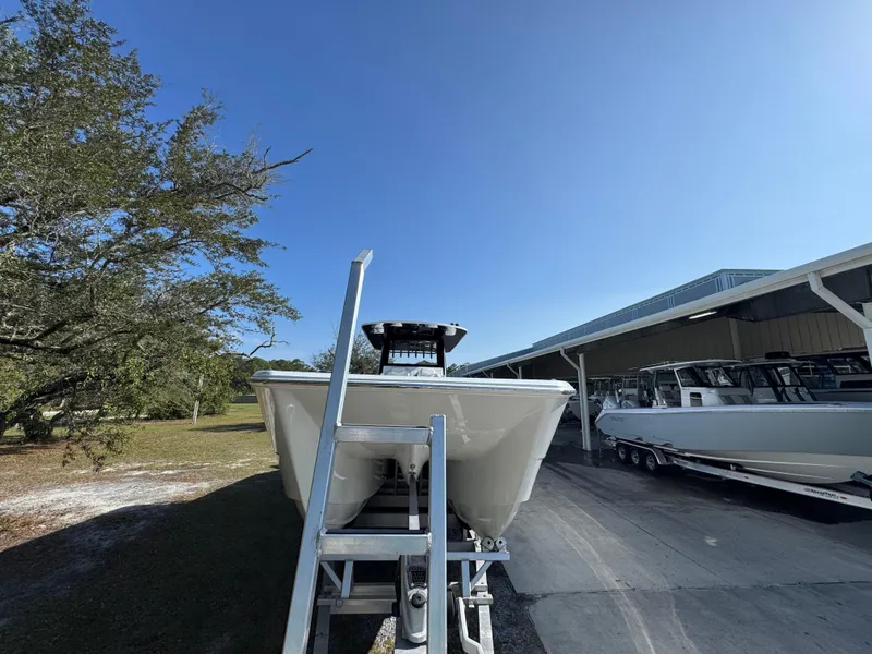 Slide: The Image of 2025 Invincible 38 Catamaran on trailer, parked outdoors under clear blue sky. - 6