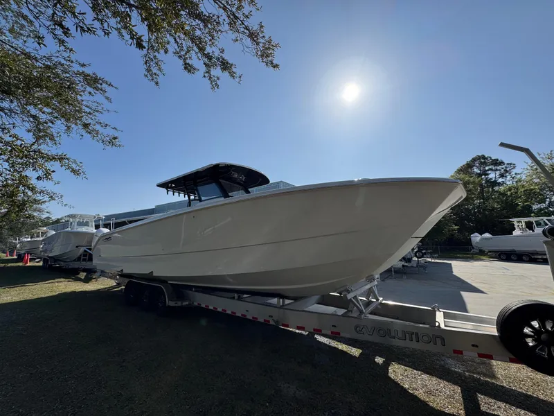 Slide: The Image of 2025 Invincible 38 Catamaran on trailer under bright sun, side view. - 8