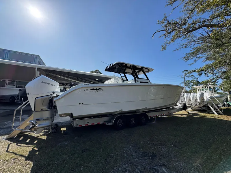 Slide: The Image of 2025 Invincible 38 Catamaran on trailer under clear blue sky. - 9