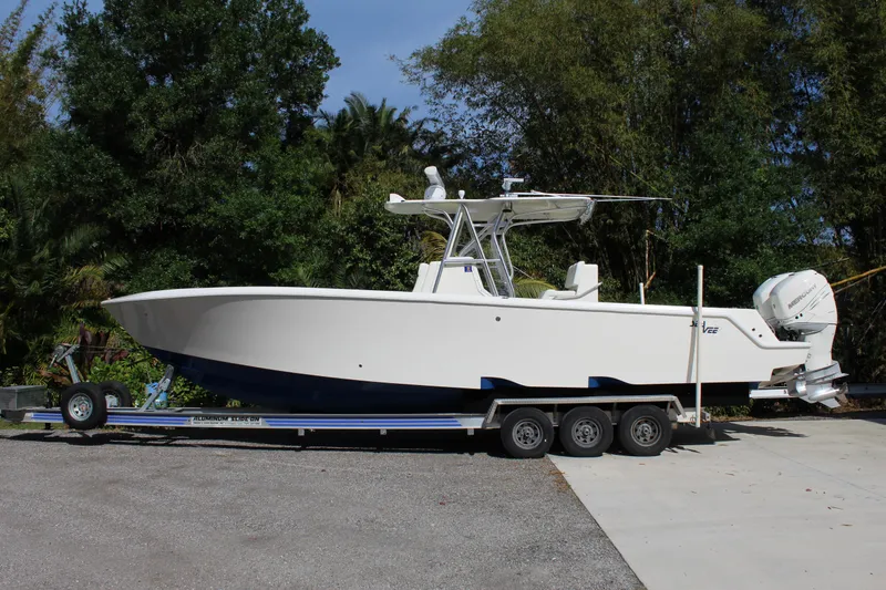 Slide: The Image of 2016 SeaVee 340Z boat on trailer, parked outdoors with lush greenery in the background. - 1