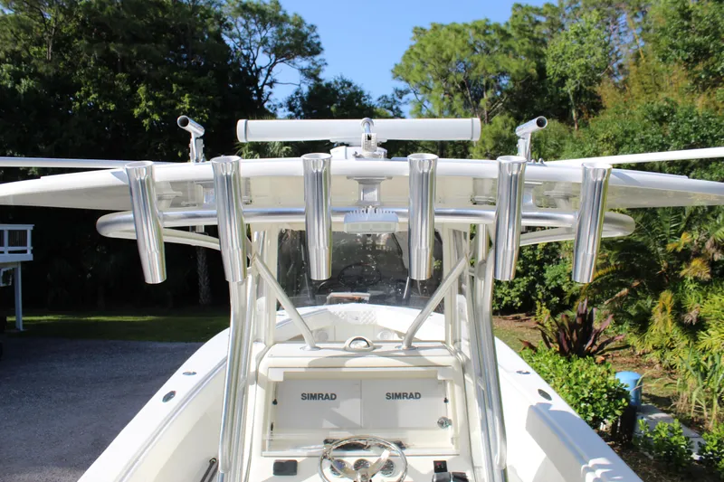 Slide: The Image of 2016 SeaVee 340Z boat with rod holders and Simrad electronics, surrounded by lush greenery. - 16