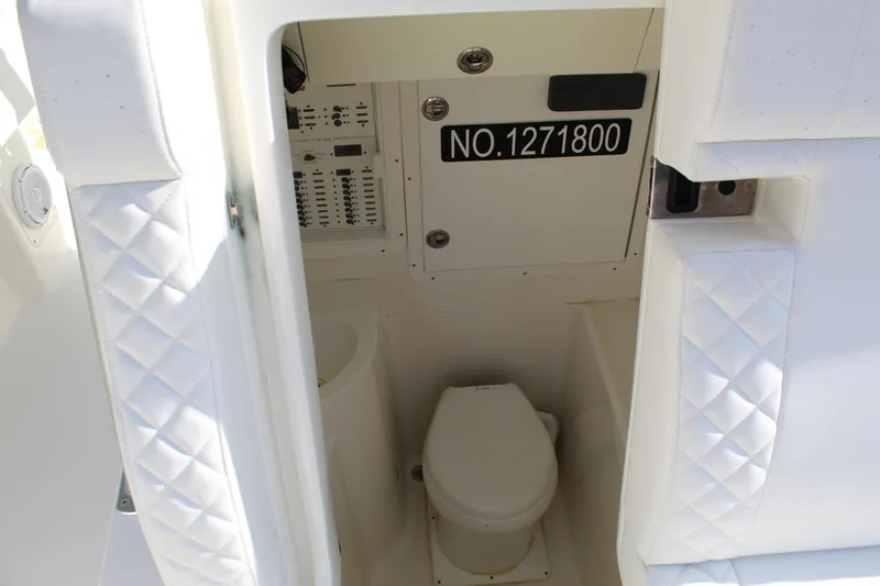 Slide: The Image of Interior view of 2016 SeaVee 340Z boat's compact bathroom with toilet and control panel. - 18