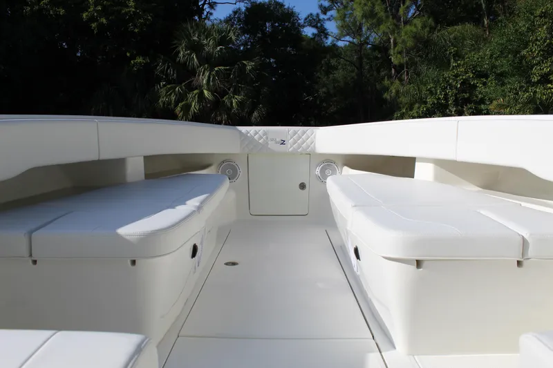 Slide: The Image of 2016 SeaVee 340Z boat interior with white seating and lush greenery background. - 21