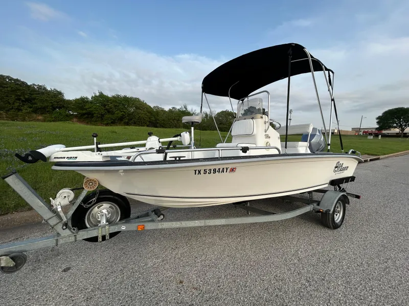 Slide: The Image of 2006 Carolina Skiff SEA CHASER boat on trailer with canopy, parked on roadside. - 0