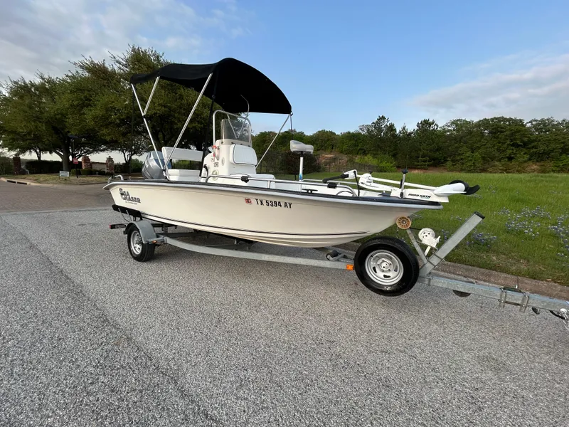 Slide: The Image of 2006 Carolina Skiff SEA CHASER boat on trailer, parked on roadside with green landscape. - 2