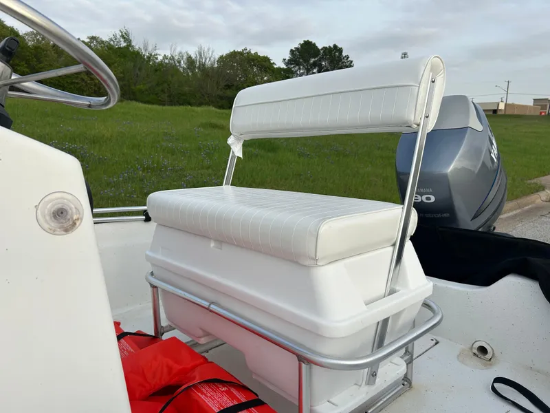 Slide: The Image of 2006 Carolina Skiff SEA CHASER boat seat with white upholstery and outboard motor. - 29