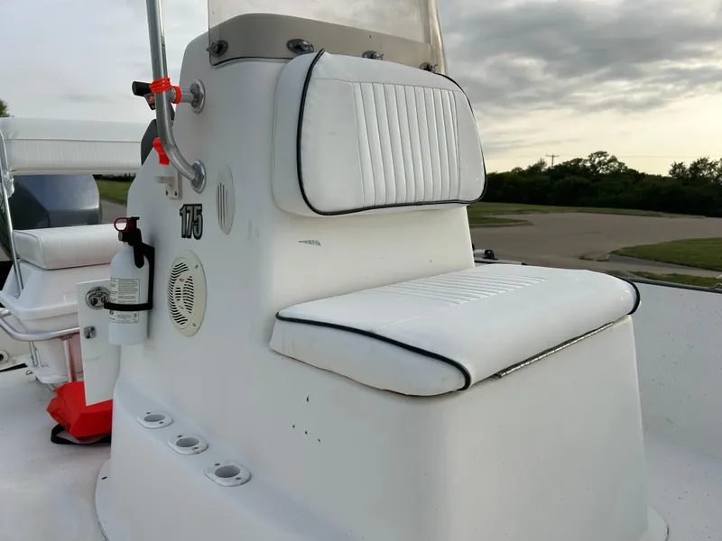 Slide: The Image of 2006 Carolina Skiff SEA CHASER boat interior with white cushioned seating and control panel. - 34