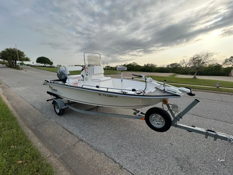 Slide: The Image of 2006 Carolina Skiff SEA CHASER boat on trailer, parked on roadside under cloudy sky. - 44