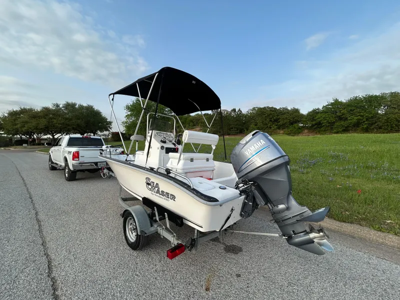 Slide: The Image of 2006 Carolina Skiff SEA CHASER boat on trailer, parked on roadside with truck. - 7