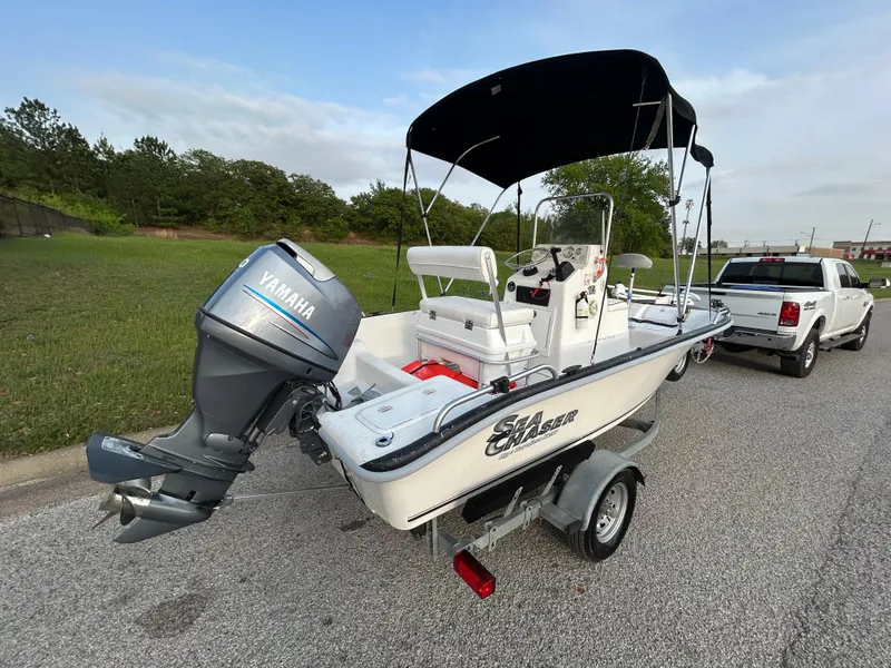 Slide: The Image of 2006 Carolina Skiff SEA CHASER boat on trailer with Yamaha outboard motor, parked near a truck. - 9