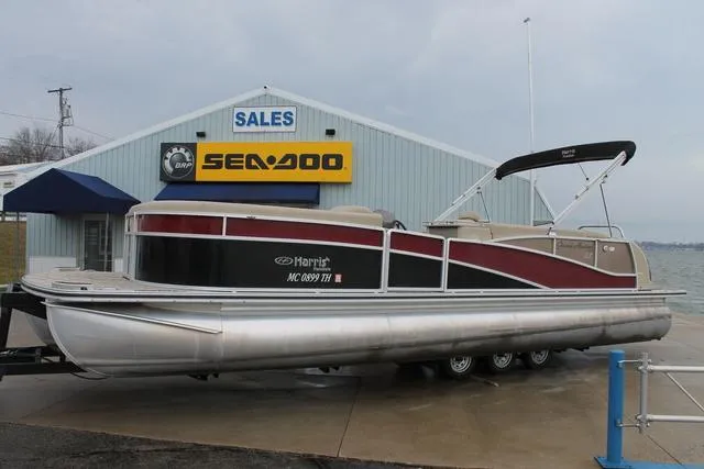 Slide: The Image of 2011 Harris 250 SL Grand Mariner pontoon boat at dealership with Sea-Doo sign. - 1
