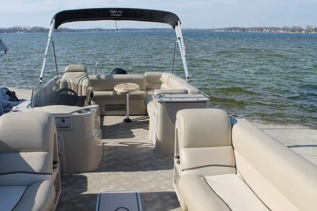 Slide: The Image of 2011 Harris 250 SL Grand Mariner pontoon boat with beige seating on a lake. - 23