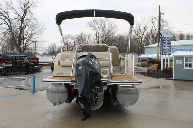 Slide: The Image of 2011 Harris 250 SL Grand Mariner pontoon boat with outboard motor, parked on concrete. - 4