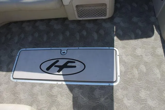 Slide: The Image of 2011 Harris 250 SL Grand Mariner boat interior with logo on carpeted floor. - 9