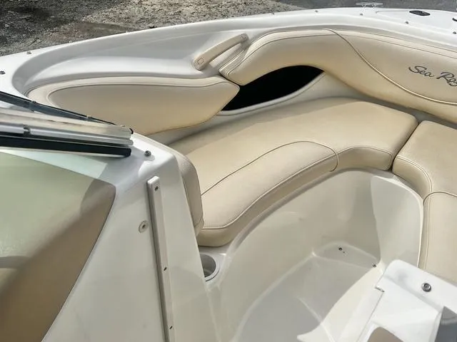 Slide: The Image of 2000 Sea Ray 210 Signature Bowrider interior with beige seating and sleek design. - 13